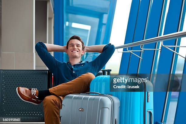 young man in an airport lounge - happy casual man stock pictures, royalty-free photos & images