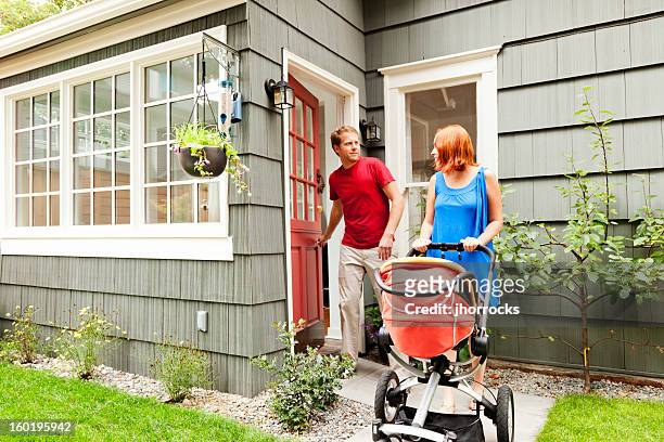 young family leaving home with baby stroller - blue house red door stock pictures, royalty-free photos & images