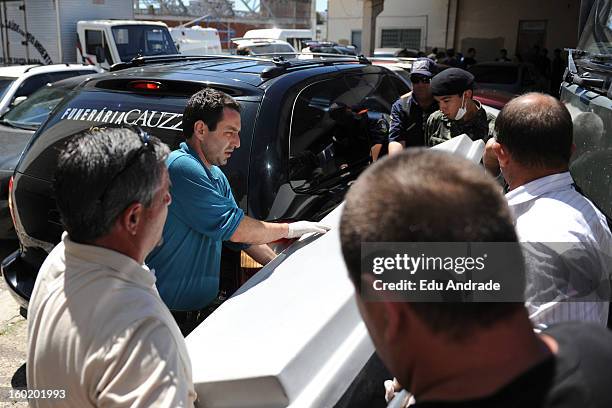 The police carry a coffin after last night fire in Santa Maria on January 27, 2013 in Santa Maria, Brazil. Last night the nightclub Kiss caught fire...