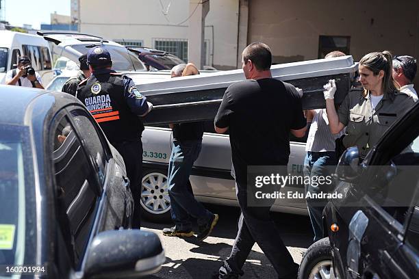 The police carry a coffin after last night fire in Santa Maria on January 27, 2013 in Santa Maria, Brazil. Last night the nightclub Kiss caught fire...
