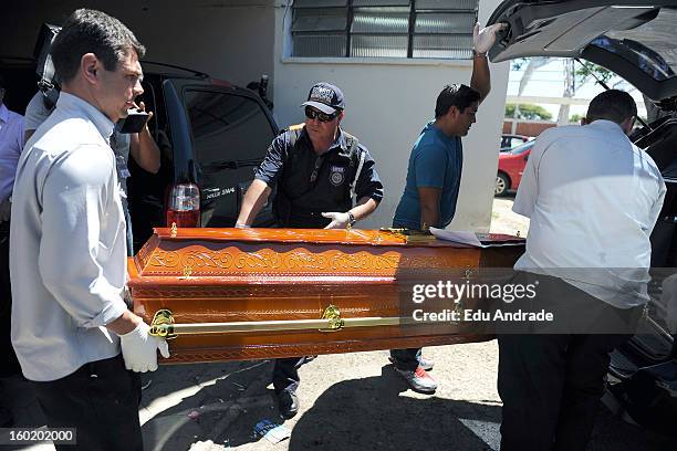 The police carry a coffin after last night fire in Santa Maria on January 27, 2013 in Santa Maria, Brazil. Last night the nightclub Kiss caught fire...