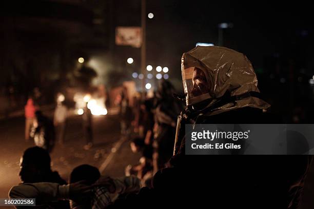 An Egyptian protester wears a makeshift gas mask during clashes with riot police near Tahrir Square on January 27, 2013 in Cairo, Egypt. Violent...