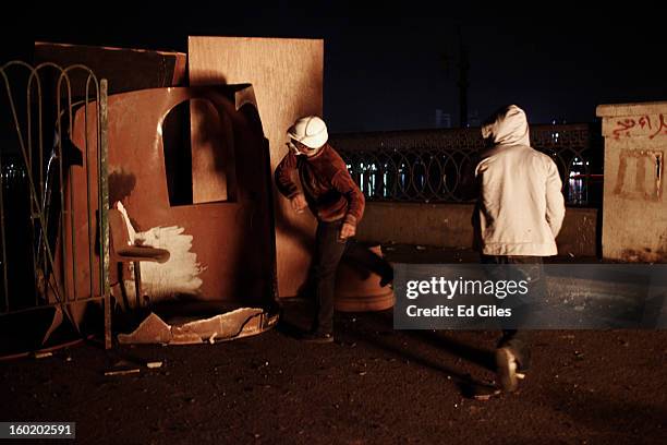 An Egyptian protester throws a rock towards riot police during clashes near Tahrir Square on January 27, 2013 in Cairo, Egypt. Violent protests...