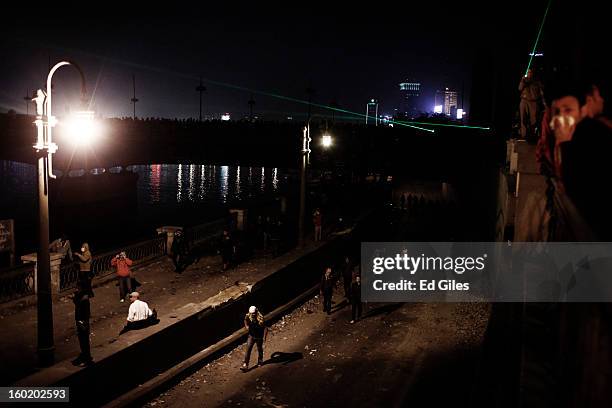 Egyptian protesters walk under an overpass toward nearby riot police during clashes near Tahrir Square on January 27, 2013 in Cairo, Egypt. Violent...