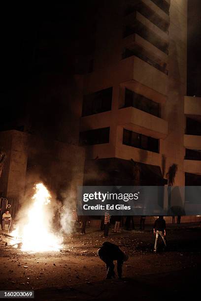 An Egyptian protester stands by a fire lit during clashes with riot police outside the luxury Intercontinental hotel near Tahrir Square on January...