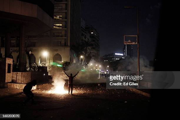 An Egyptian protester gestures toward a line of riot police during clashes with Egyptian security forces near Tahrir Square on January 27, 2013 in...