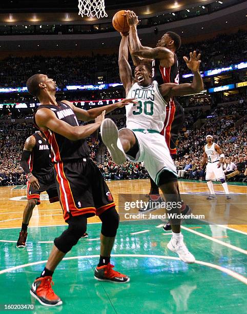 Brandon Bass of the Boston Celtics fights for a loose ball with Udonis Haslem of the Miami Heat during the game on January 27, 2013 at TD Garden in...