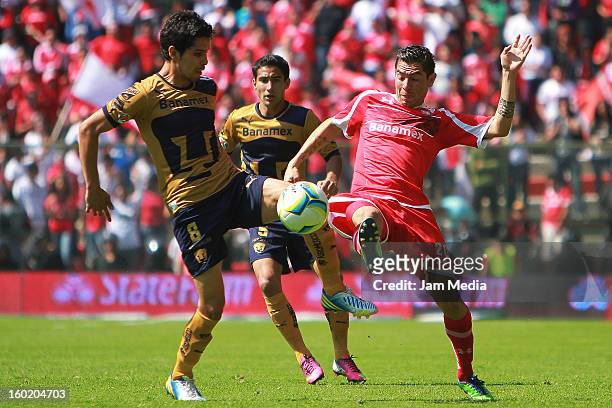 Flavio Santos of Toluca struggles for the ball with David Cabrera of Pumas during the Clausura 2013 Liga MX at Nemesio Diez Stadium on january 27,...