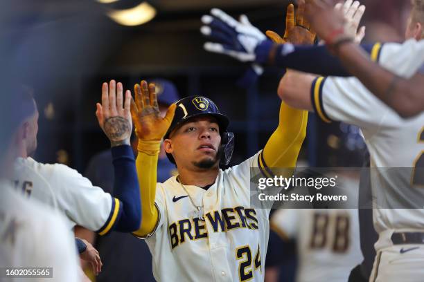 William Contreras of the Milwaukee Brewers is congratulated by teammates following a home run against the Colorado Rockies during the fourth inning...