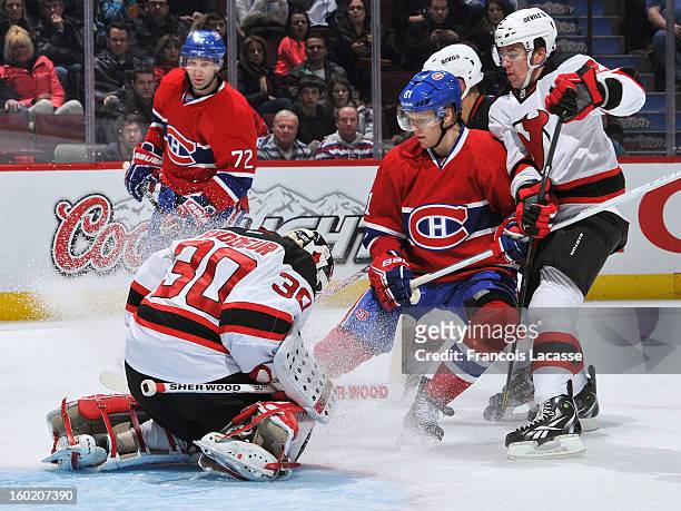 Larc Eller of the Montreal Canadiens looks for a loose puck in front of goalie Martin Brodeur of the New Jersey Devils as during the NHL game on...