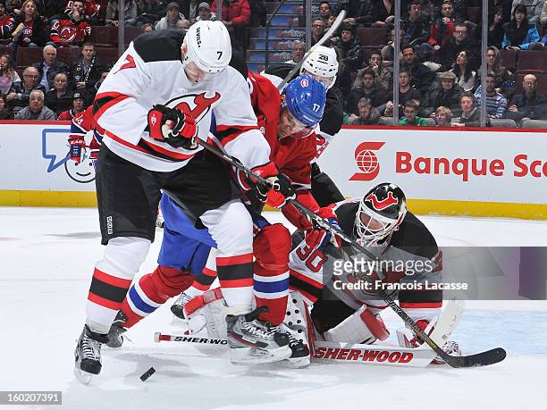 Henrik Tallinder of the New Jersey Devils and Rene Bourque of the Montreal Canadiens fight for a loose puck in front of goalie Martin Brodeur during...