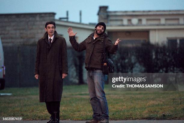 French photographer William Daniels raises his arms to celebrate his arrival in France, after the plane carrying him and French journalist Edith...