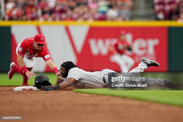 Josh Bell of the Miami Marlins slides into second base for a double past Matt McLain of the Cincinnati Reds in the sixth inning at Great American...