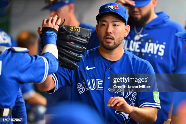 Starting pitcher Yusei Kikuchi of the Toronto Blue Jays celebrates with teammates in the dugout after the sixth inning against the Cleveland...