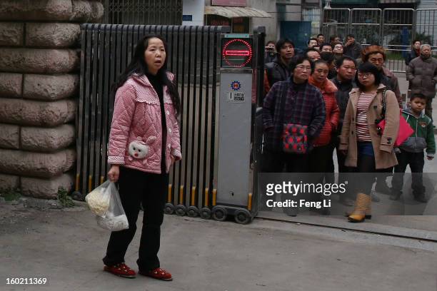 Residents look on outside Guiyang Intermediate People's Court as media rushing into the court yard before a press conference on former Chinese leader...