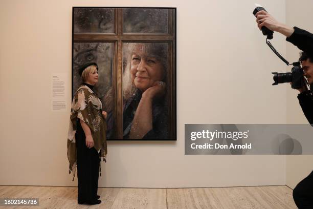 Media photographer takes a picture of Jaq Grantford and her Archibald People's Choice Award winning portrait of Noni Hazelhurst titled 'Through the...