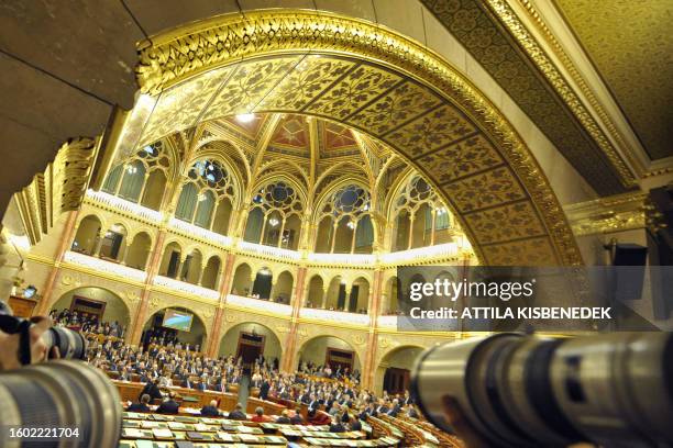 Photographers take pictures from the press box, as Hungarian Prime Minister Ferenc Gyurcsany announces a planned tax package during a plenary session...