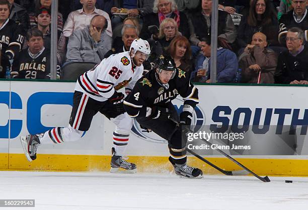 Brenden Dillon of the Dallas Stars tries to keep the puck away against Viktor Stalberg of the Chicago Blackhawks at the American Airlines Center on...