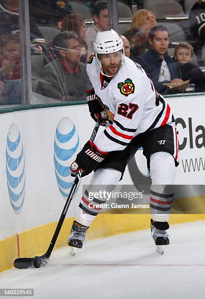 Johnny Oduya of the Chicago Blackhawks handles the puck against the Dallas Stars at the American Airlines Center on January 24, 2013 in Dallas, Texas.