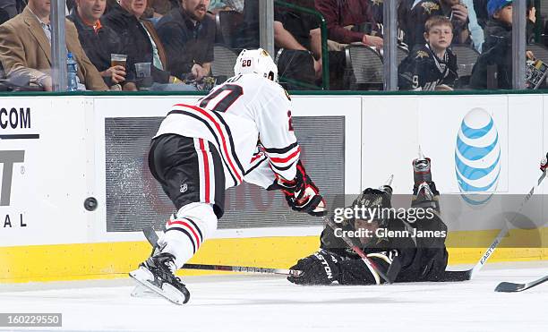 Ryan Garbutt of the Dallas Stars dives to try and get the puck out of the zone against Brandon Saad of the Chicago Blackhawks at the American...