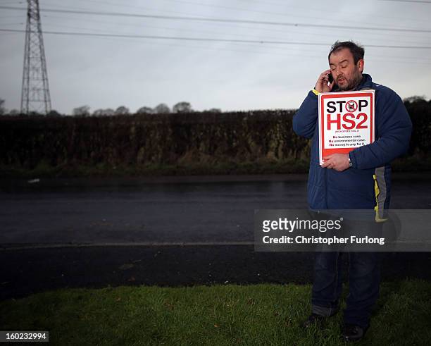 Joe Rukin from the Stop the HS2 Campaign talks on a mobile phone near to the planned location of the new HS2 high speed rail link as it passes by the...