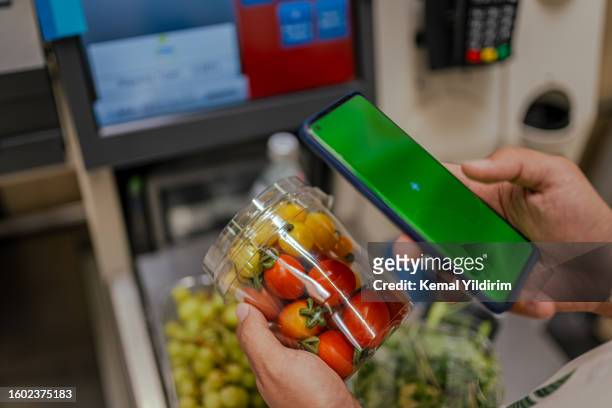handsome man searching for groceries from the list on is mobile phone - scanner stock stock pictures, royalty-free photos & images