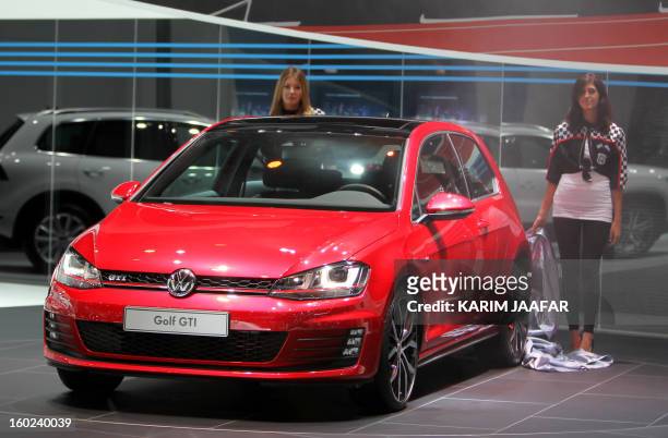 Models unveil the Volkswagen Golf Gti during the third International Qatar Auto Show on January 28, 2013 in Doha. AFP PHOTO / AL-WATAN DOHA / KARIM...