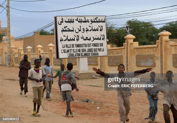 Children wave after Malian and French soldiers entered the historic city of Timbuktu, occupied for 10 months by Islamists who imposed a harsh form of...