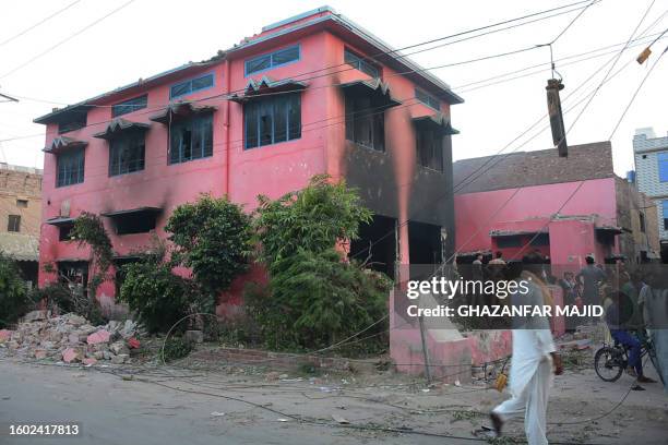 People gather outside a burnt church on the outskirts of Faisalabad on August 16 following an attack by Muslim men after a Christian family was...