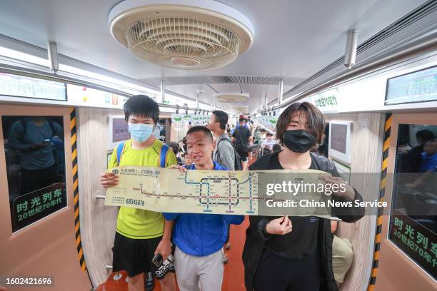 Passengers show route map on a 1960s-themed subway train from Beijing Subway Line 1, marking the first immersive 'time-traveling' experience on a...