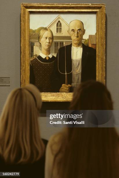 People looking at a painting of Grant Wood - The American Gothic at the Art Institute in Chicago, in Chicago in 1987