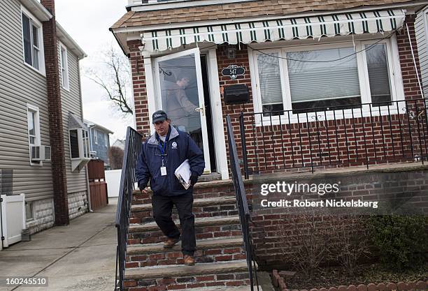 Representative surveys a resident about heat and power availability January 17, 2013 in a neighborhood damaged during Hurricane Sandy in the...