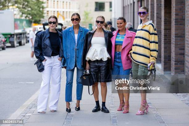 Annabel Rosendahl wears black leather jacket, white pants, bag & Darja Barannik wears oversized denim blazer, jeans & Tine Andrea wears ruffled creme...