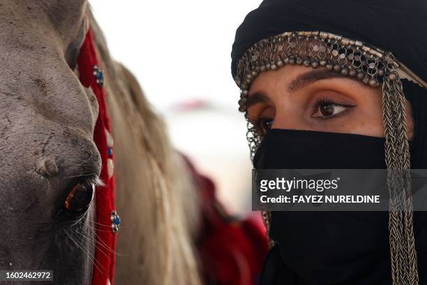 Saudi equestrian Noura Al-Jabr stands next to her horse at a training centre in Dammam, in Saudi Arabia's eastern province on August 14, 2023. Jabr...