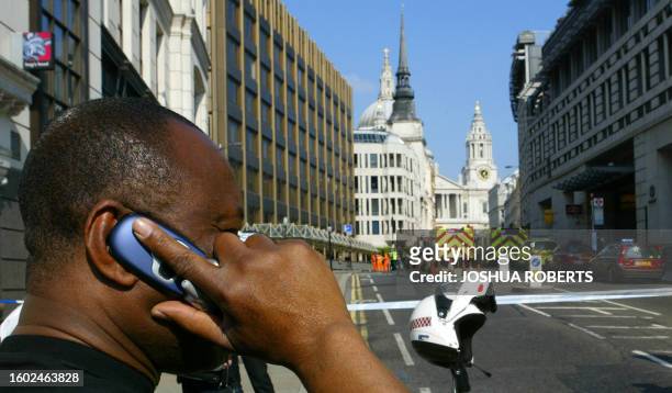 Man speaks on his mobile phone after police closed Ludgate Hill near St Paul's Cathedral in London 21 July 2005, when a suspect package was found in...