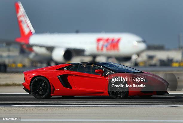 New Lamborghini Aventador LP700-4 Roadster is seen as it is driven along the south runway at the Miami International Airporton January 28, 2013 in...