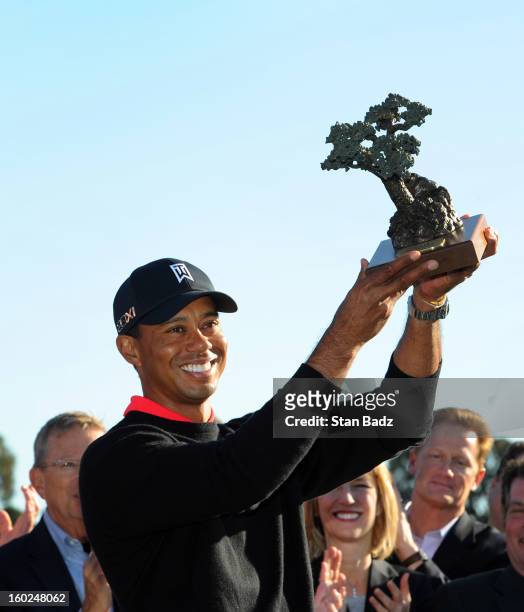 Tiger Woods poses with the trophy celebrating his win at the Farmers Insurance Open at Torrey Pines Golf Course on January 28, 2013 in La Jolla,...