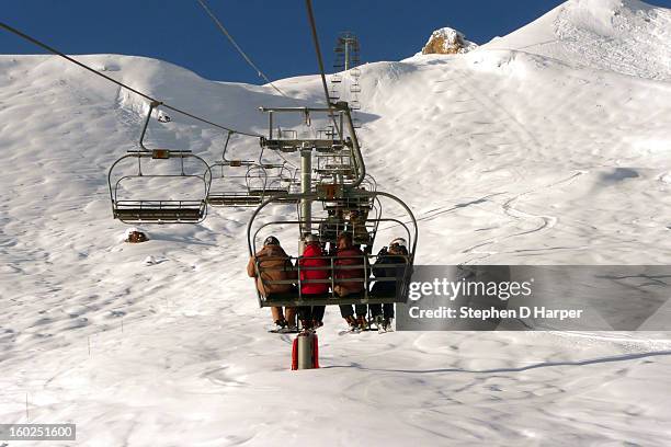 skiers on a chairlift at espace killy - espace killy stock pictures, royalty-free photos & images