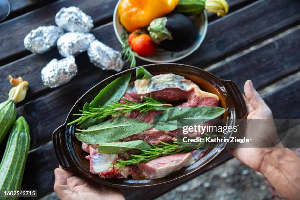 man holding a dish with marinated meat, pov - gebackene kartoffel stock-fotos und bilder