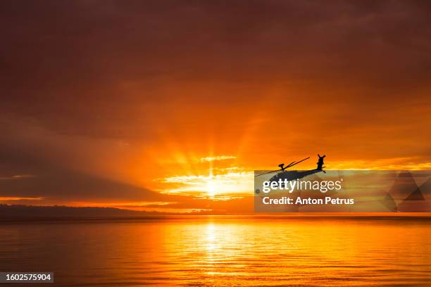 military helicopter at sunset over the sea - attack helicopter stock pictures, royalty-free photos & images