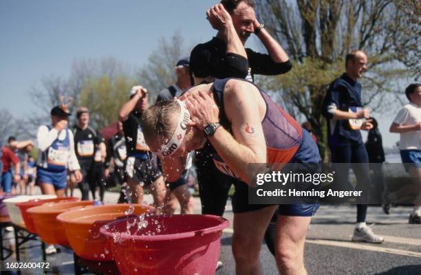 Runner splashes water from a basin as they cool down during the Hamburg Marathon in Hamburg, Germany, 21st April 2002. Named for the sponsorship...