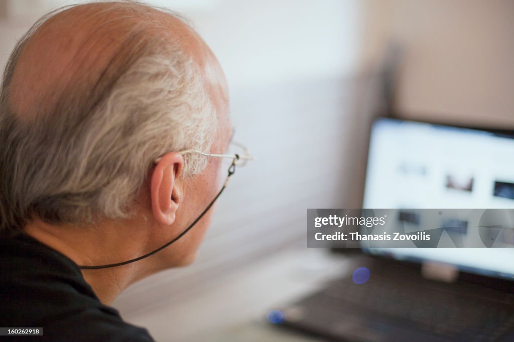 Old man looking at a laptop