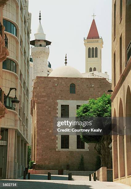 Mosque''s minaret and a church''s steeple stand next to each other July 17, 2001 in the reborn downtown area of Beirut which has undergone ten years...