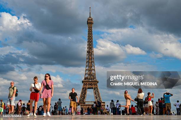 Members of the public walk away from the Eiffel Tower in Paris on August 16, 2023.