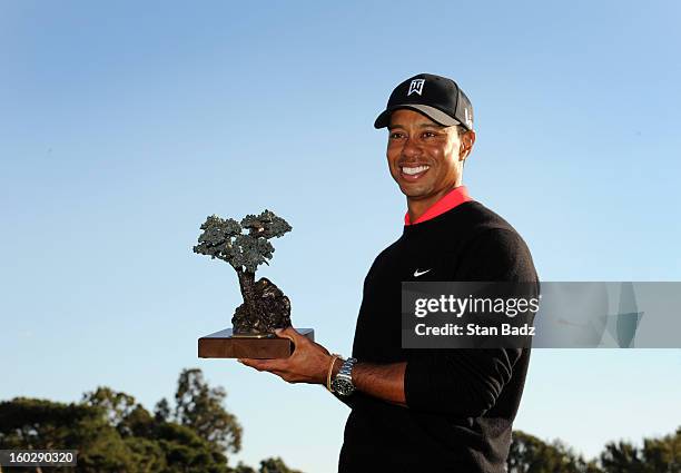 Tiger Woods poses with the trophy celebrating his win at the Farmers Insurance Open at Torrey Pines Golf Course on January 28, 2013 in La Jolla,...