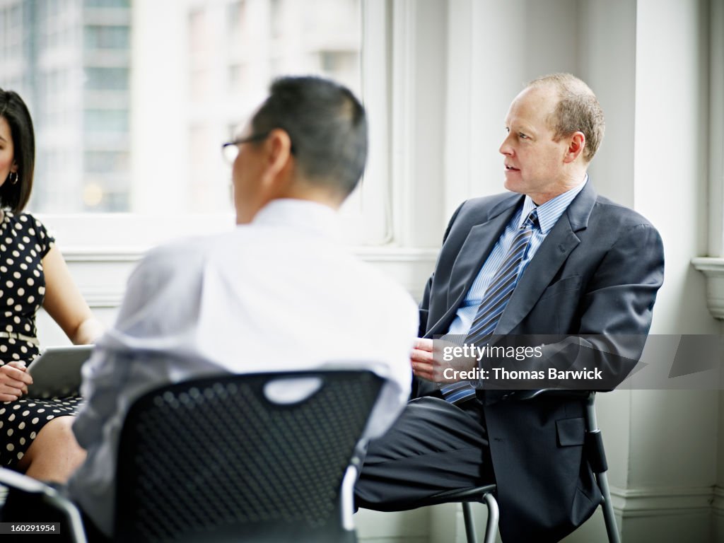 Coworkers discussing project in office