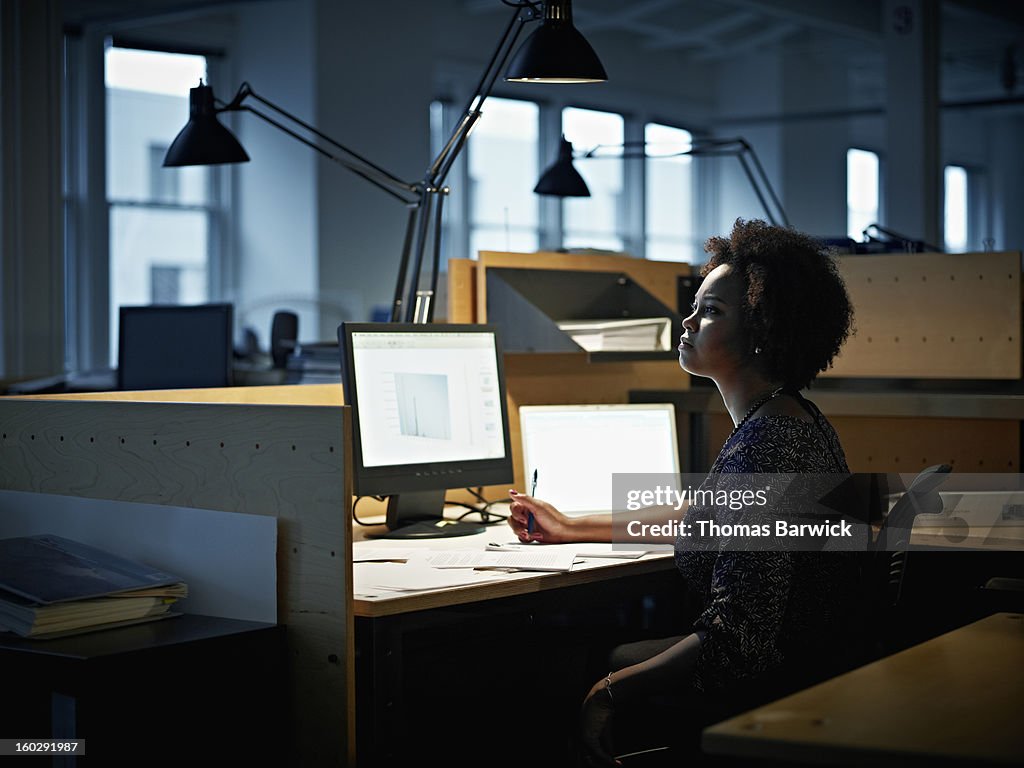 Businesswoman working at desk at night