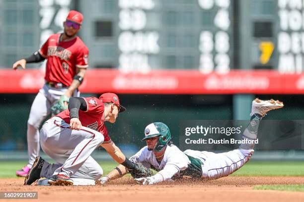 Ezequiel Tovar of the Colorado Rockies is tagged out by Nick Ahmed of the Arizona Diamondbacks on a pickoff of a steal attempt in the first inning at...