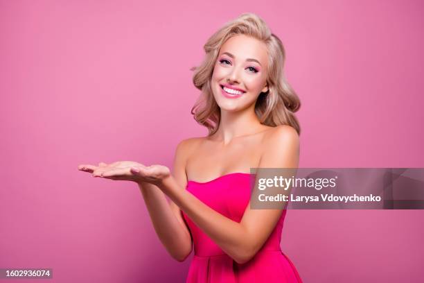 photo of dream fancy attractive lady holding demonstrate promotion on pink empty space background - barbie princess stock pictures, royalty-free photos & images