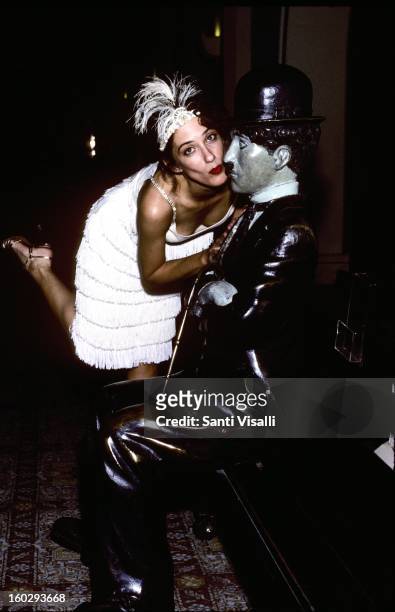 Woman dressed in costume kisses a statue of Charlie Chaplin at the Roosevelt Hotel on Hollywood Boulevard in 1990 in Los Angeles, California.